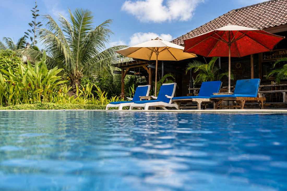 Kolam luar ruangan dengan kursi santai dan payung